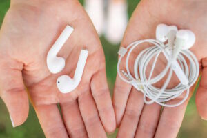 Female hands holding wired and wireless headphones in his hand